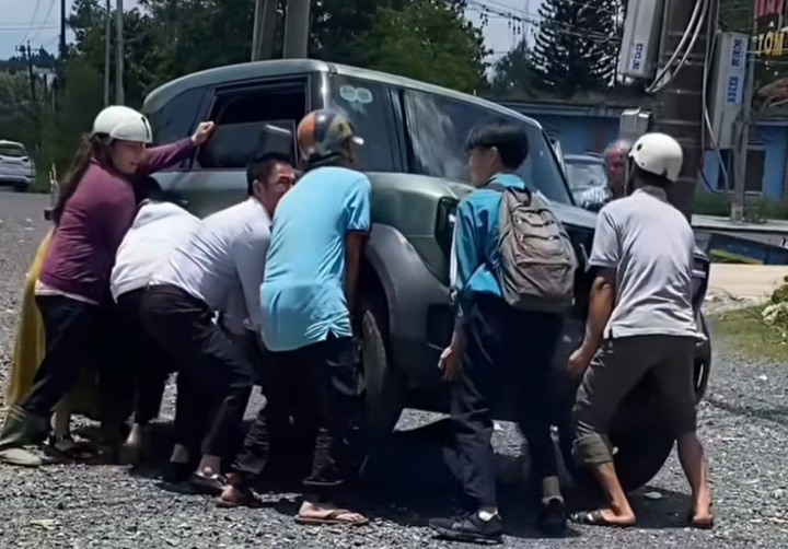 Người dân khiêng chiếc ô tô lên để giải cứu nữ sinh mắc kẹt dưới gầm xe sau vụ tai nạn.